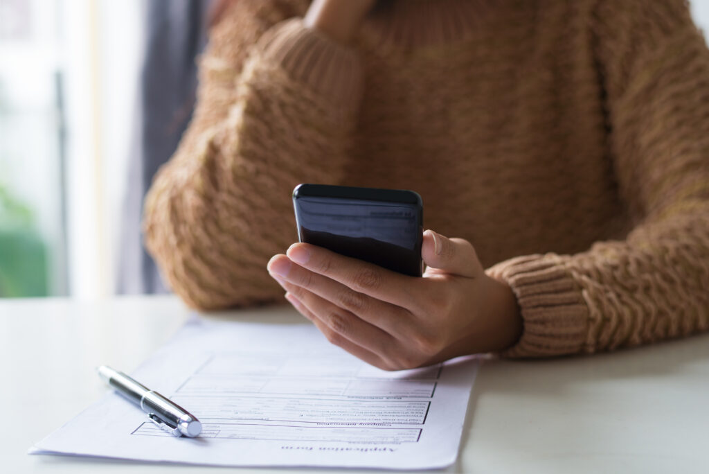 vrouw checkt document via telefoon