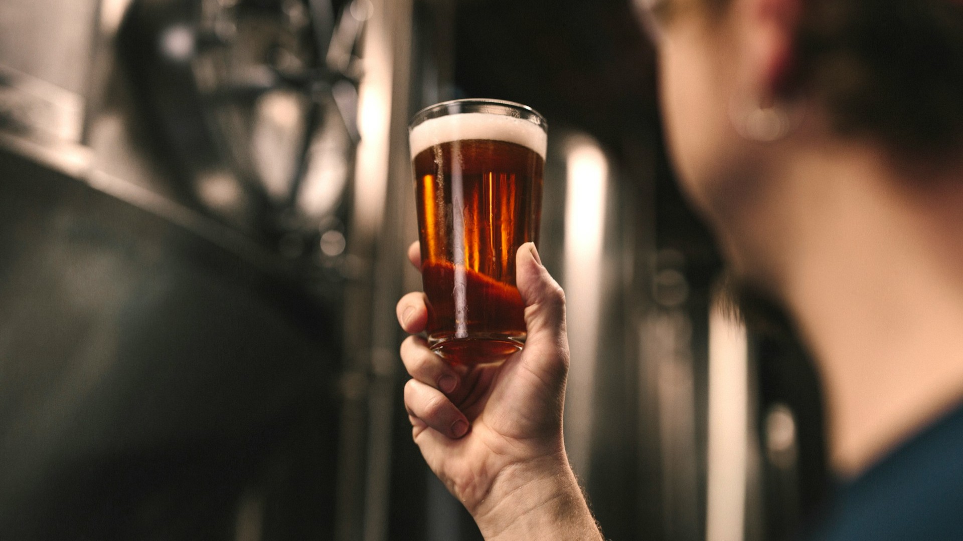 Glas amberkleurig bier in brouwerij, voorbeeld van gefermenteerde dranken met schuimkraag